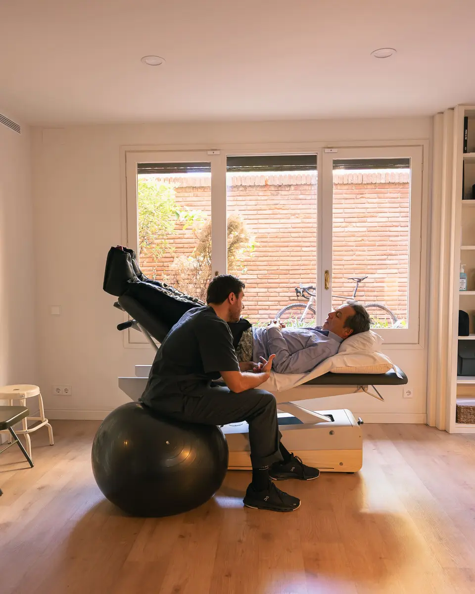 Fisioterapeuta tratando a un paciente sobre un fitball en el estudio de 90 Degrees