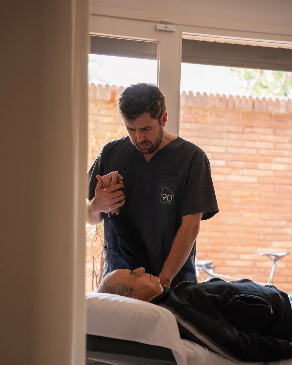 Fisioterapeuta aplicando terapia manual a un paciente en camilla